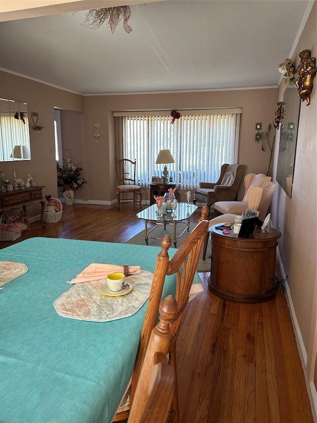 dining space featuring ornamental molding, baseboards, and wood finished floors