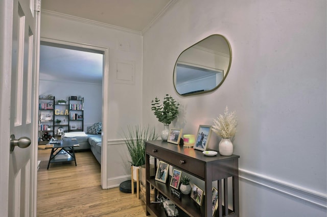 corridor featuring light wood finished floors and crown molding