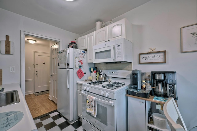 kitchen with white appliances, decorative backsplash, light countertops, white cabinets, and tile patterned floors