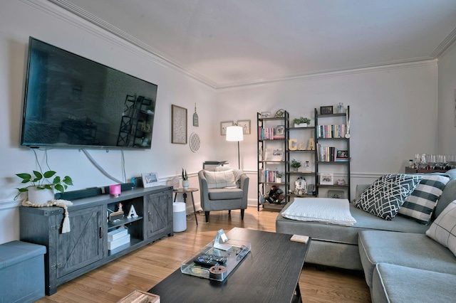 living room with crown molding and light wood-style flooring