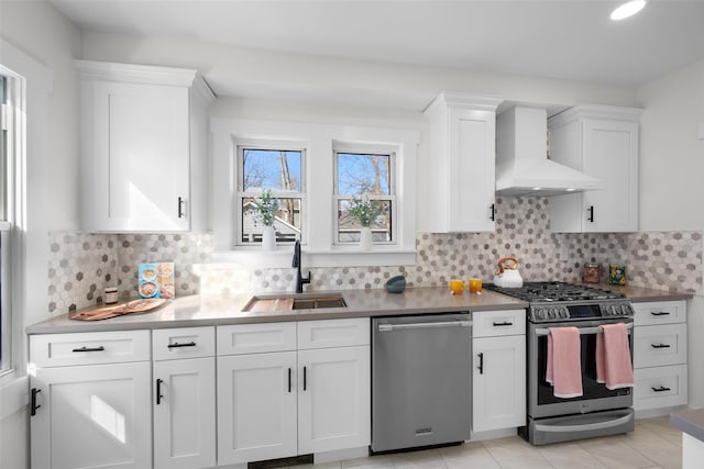 kitchen with tasteful backsplash, stainless steel appliances, custom exhaust hood, white cabinetry, and a sink