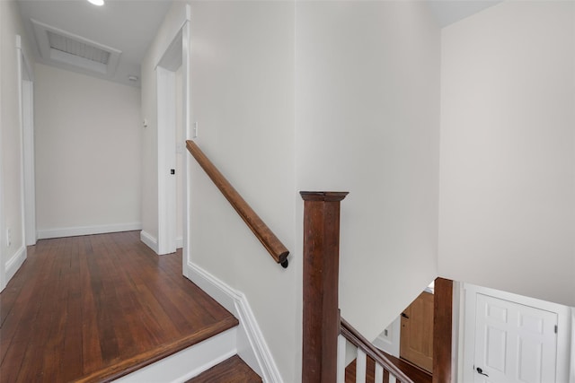 staircase featuring visible vents, baseboards, attic access, and wood finished floors