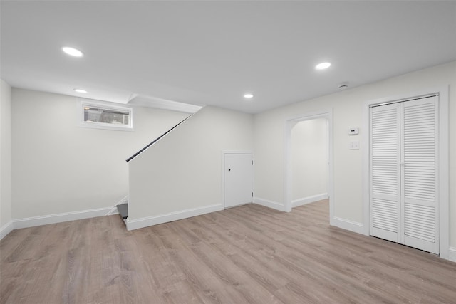 finished basement featuring light wood finished floors, recessed lighting, and baseboards