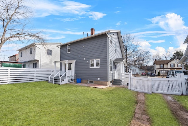 back of property with a lawn, a chimney, and fence