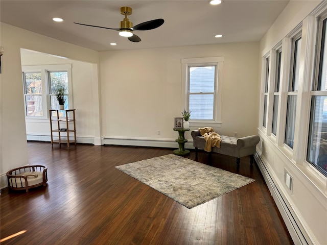 living area with recessed lighting, a baseboard radiator, a ceiling fan, and dark wood-style flooring