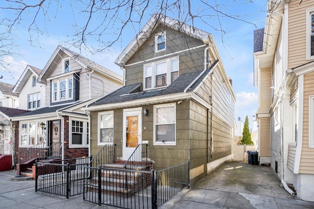 view of front of home with entry steps, fence, and roof with shingles