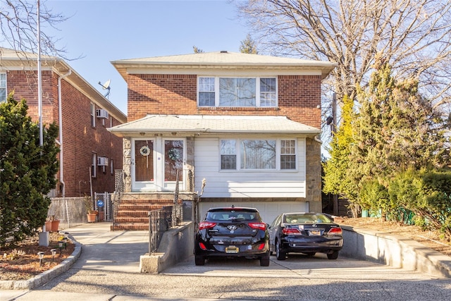 view of front facade featuring brick siding, driveway, and a garage