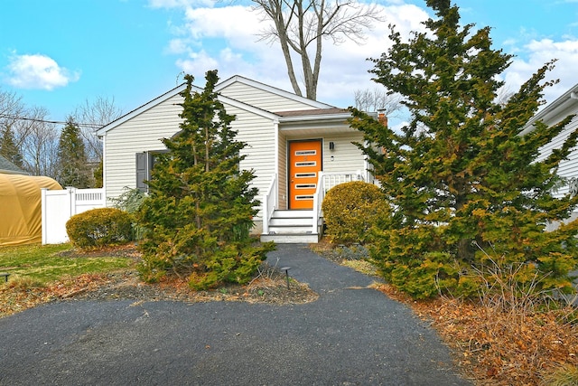 view of front of house with a chimney and fence