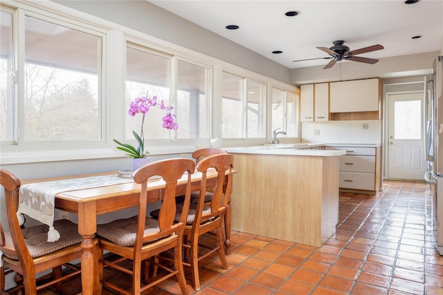 kitchen featuring a sink, a healthy amount of sunlight, a peninsula, and light countertops