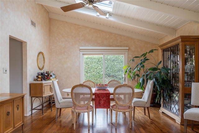 dining space featuring lofted ceiling with skylight, wood finished floors, visible vents, and ceiling fan