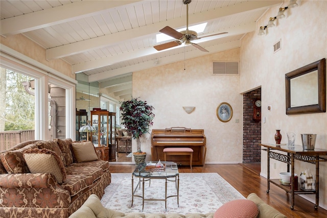 living room with ceiling fan, visible vents, beam ceiling, and wood finished floors