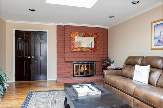 living room with a fireplace, crown molding, baseboards, and wood finished floors