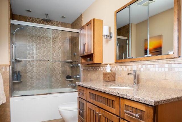 full bath featuring a combined bath / shower with rainfall shower, toilet, tile walls, and vanity