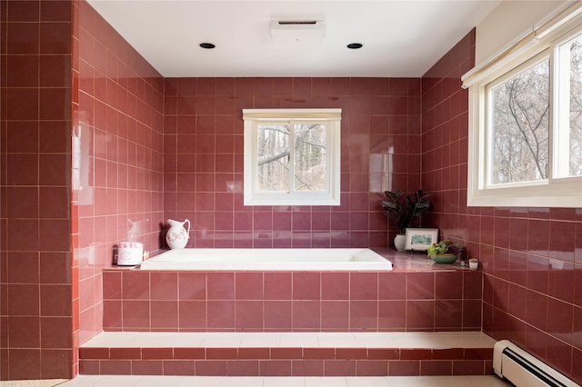 bathroom featuring plenty of natural light, baseboard heating, tile walls, and a bath