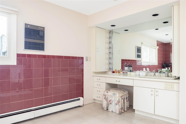 bathroom with a baseboard heating unit, tile walls, vanity, and tile patterned flooring