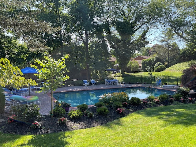 view of swimming pool featuring a yard, fence, and a fenced in pool