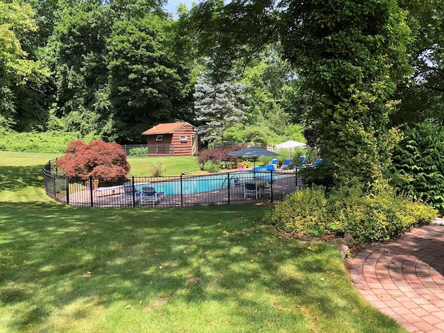 view of swimming pool featuring a lawn, a fenced in pool, and fence