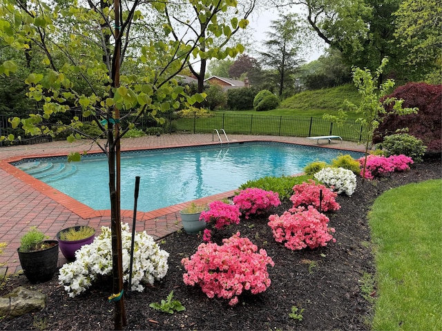 view of pool featuring a diving board, fence, and a fenced in pool