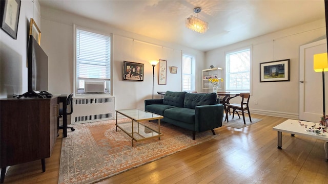 living room featuring hardwood / wood-style floors, radiator, cooling unit, and baseboards