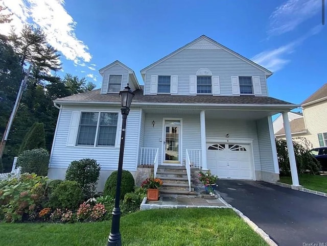 view of front facade featuring an attached garage, a porch, and driveway