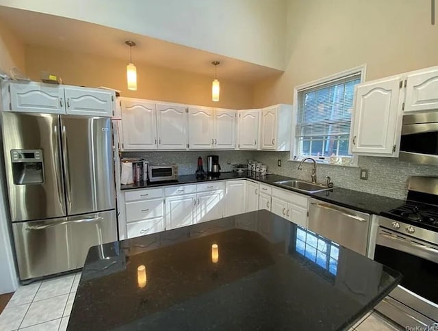 kitchen with a sink, stainless steel appliances, backsplash, and white cabinets