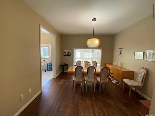 dining room with dark wood-type flooring and baseboards