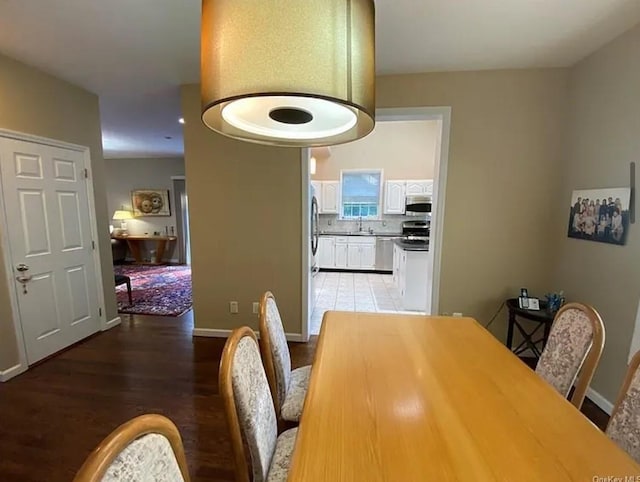 dining space featuring baseboards and light wood finished floors