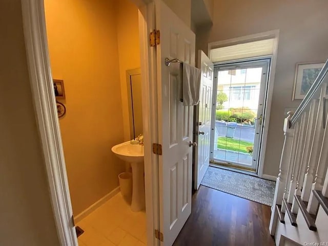 doorway featuring baseboards and wood finished floors