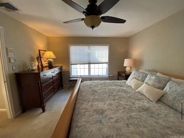 bedroom featuring visible vents, baseboards, light colored carpet, and ceiling fan