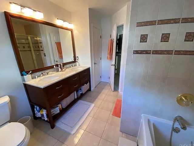 bathroom with tile patterned flooring, double vanity, toilet, and a sink