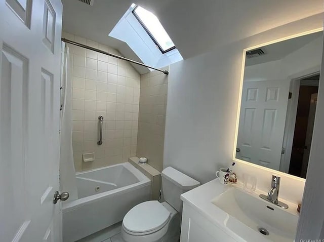 bathroom featuring lofted ceiling with skylight, vanity, toilet, and shower / tub combo