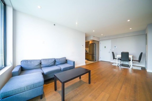 living area with recessed lighting, wood finished floors, and baseboards