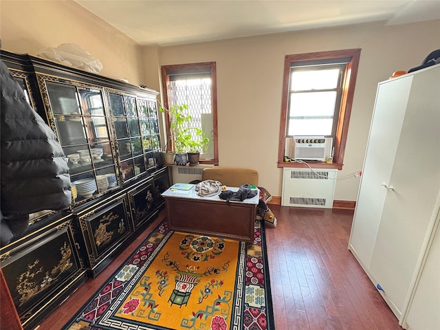 home office with cooling unit, radiator, baseboards, and hardwood / wood-style flooring