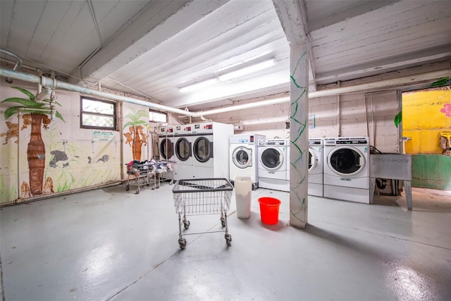 common laundry area featuring washing machine and dryer and a sink