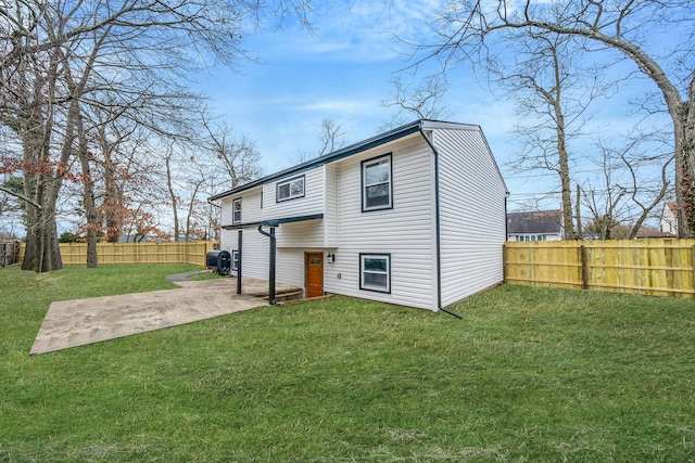 back of house featuring a yard, a fenced backyard, and a patio