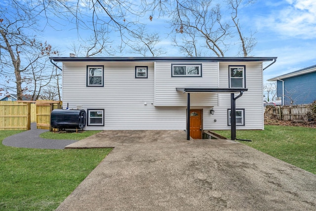 raised ranch featuring a front yard, heating fuel, fence, and a patio