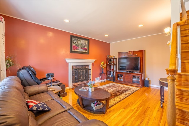 living room featuring a fireplace, recessed lighting, wood finished floors, and baseboards