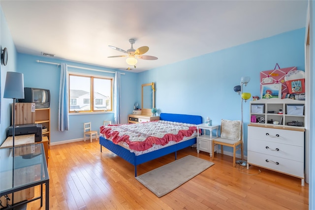 bedroom featuring visible vents, baseboards, a ceiling fan, and hardwood / wood-style flooring