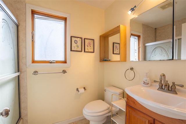 full bath featuring vanity, baseboards, visible vents, an enclosed shower, and toilet