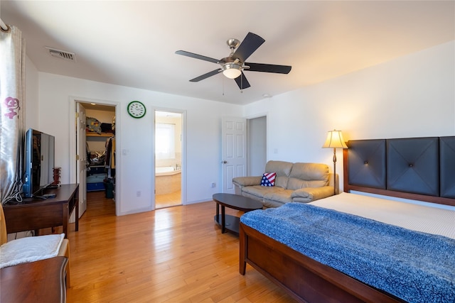 bedroom with visible vents, a walk in closet, ceiling fan, light wood-type flooring, and a closet