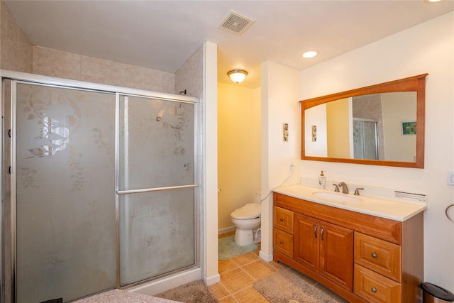 bathroom with visible vents, toilet, a stall shower, tile patterned flooring, and vanity