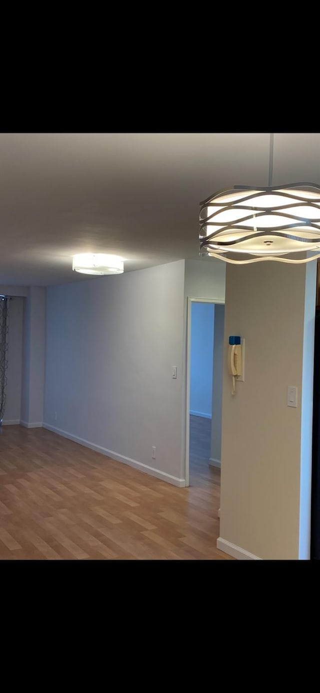 unfurnished room with baseboards and light wood-type flooring