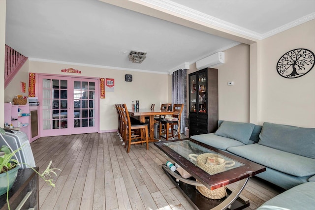 living room with a wall mounted air conditioner, ornamental molding, hardwood / wood-style flooring, french doors, and stairway