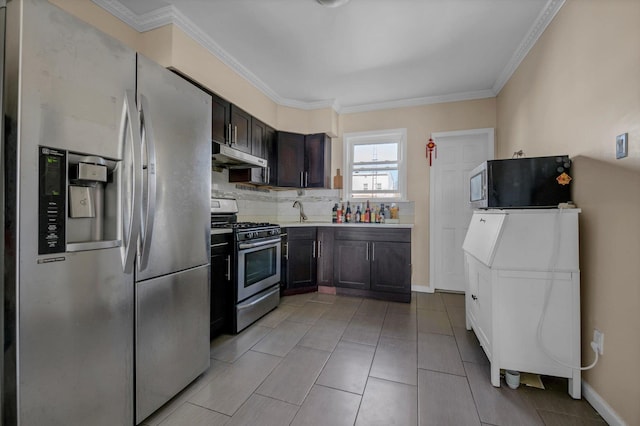 kitchen with under cabinet range hood, backsplash, stainless steel appliances, crown molding, and light countertops