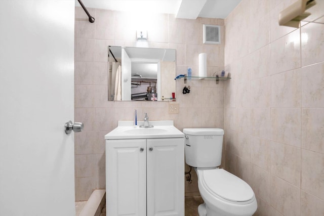 full bath with visible vents, toilet, tile walls, and vanity