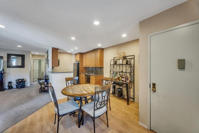 dining room featuring recessed lighting, baseboards, and light wood finished floors