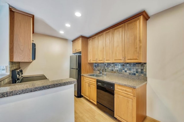 kitchen with black appliances, a sink, recessed lighting, light wood finished floors, and decorative backsplash