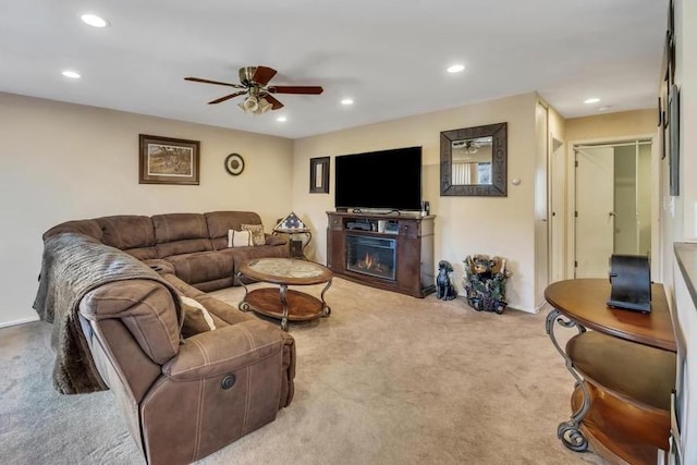 carpeted living area featuring a glass covered fireplace, recessed lighting, and a ceiling fan