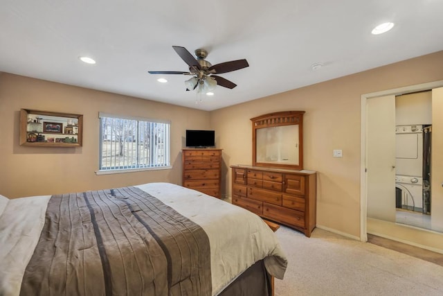 bedroom with baseboards, recessed lighting, ceiling fan, light carpet, and stacked washer / dryer