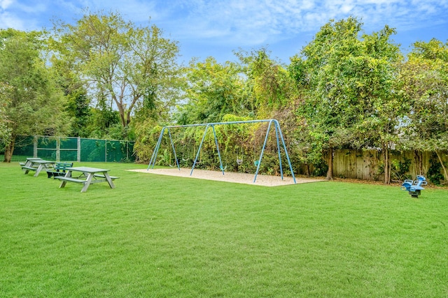 community jungle gym featuring a lawn and fence